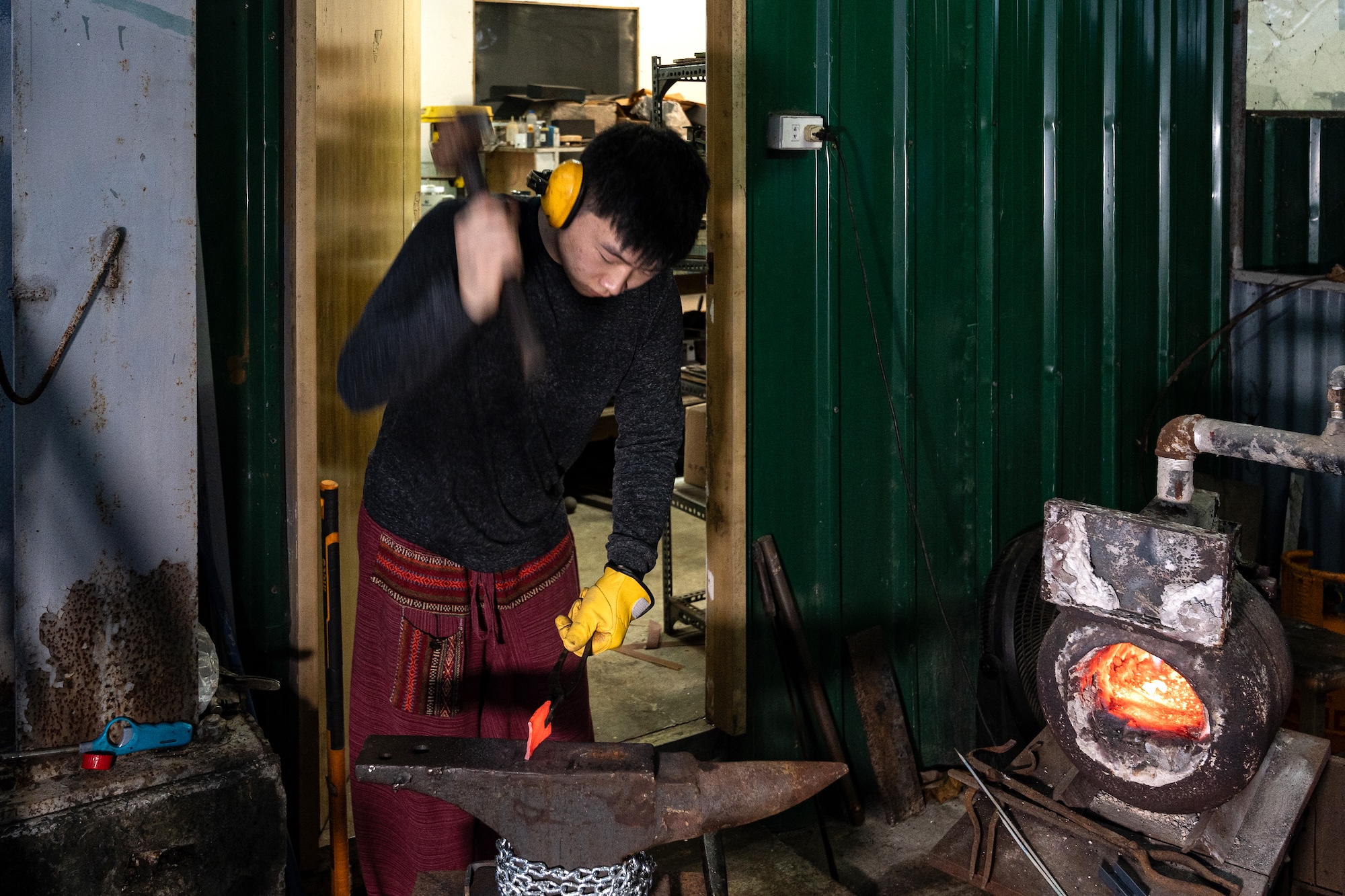 Forging steel happens just outside his studio