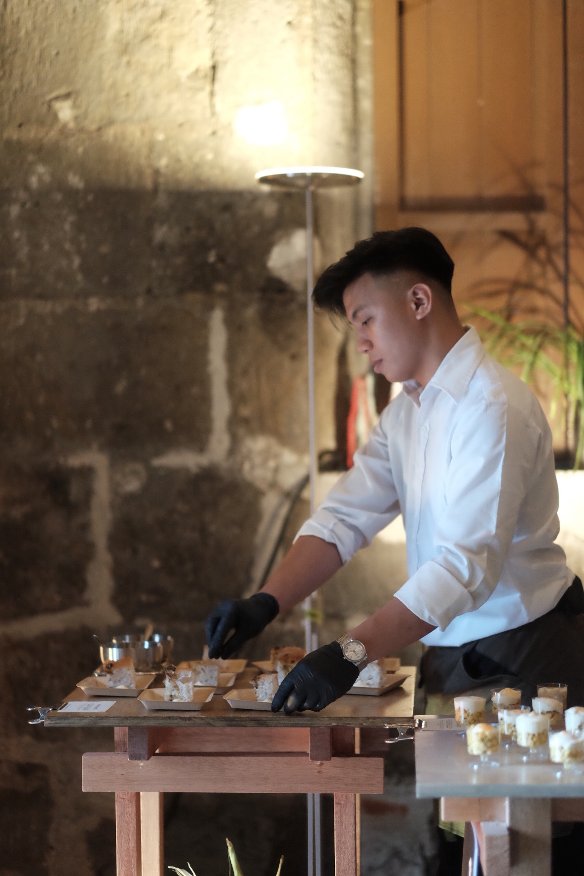 A Hatch + Hoolman Studio staff prepping the pan de maize (focaccia cornbread, extra virgin olive oil, balsamic vinaigrette, and cheese foam)