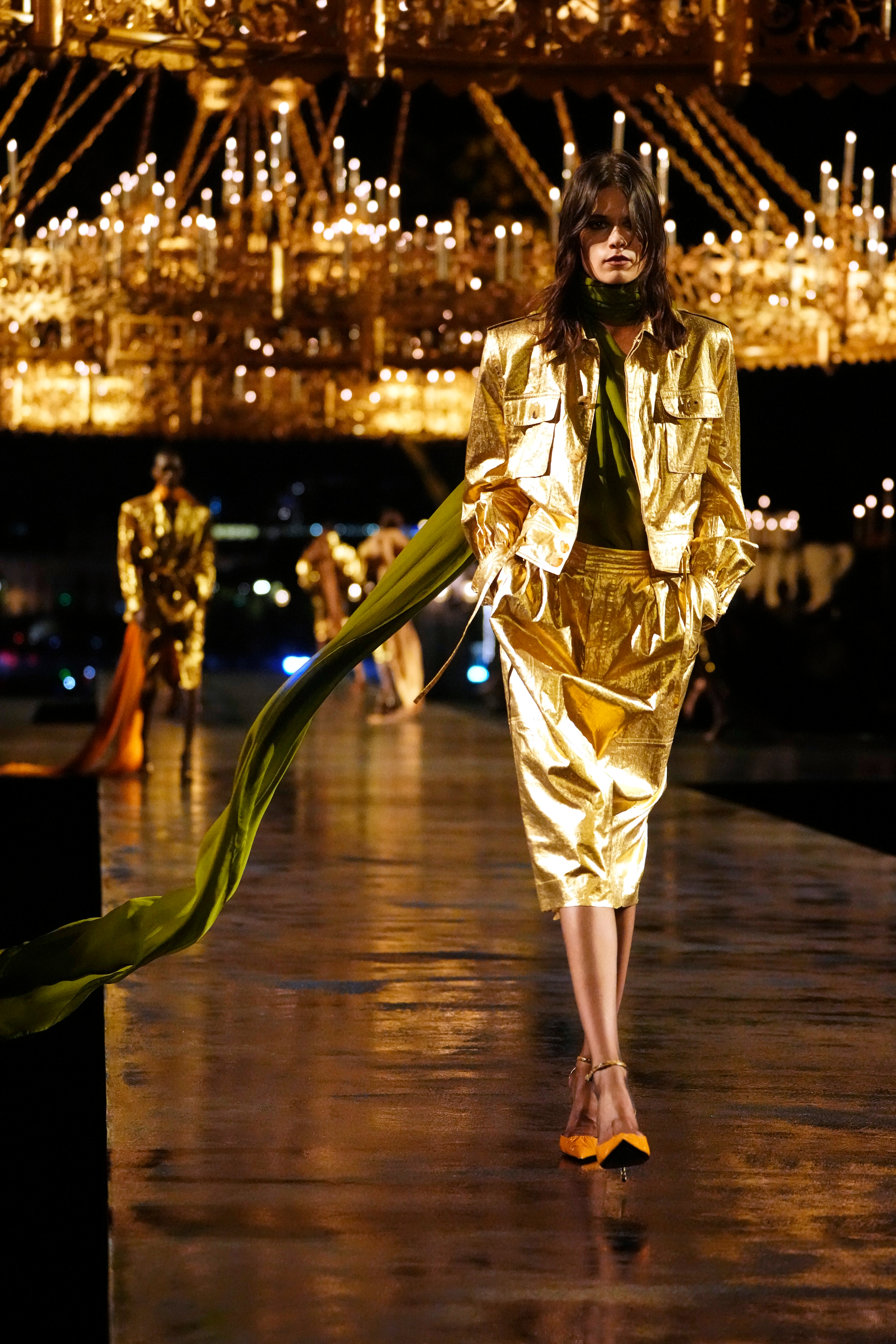 A model presents a design heavy with gold embroidery